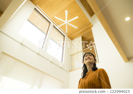 A custom-built house with an open ceiling and a woman A custom-built house with an open ceiling and a woman 122994025