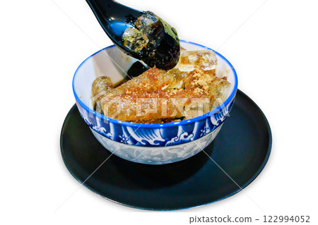 Top view of Grass jelly dessert herbal gelatin or jelly black with Cane sugar syrup, ice, in blue Chinese pattern bowl, focus selective Top view of Grass jelly dessert herbal gelatin or jelly black with Cane sugar syrup, ice, in blue Chinese pattern bowl, focus selective 122994052