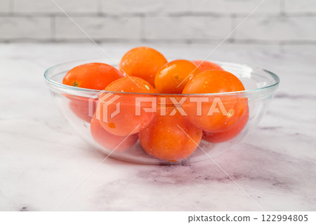Frozen tomatoes in transparent bowl, on light background. Preservation of vegetables. Natural products Frozen tomatoes in transparent bowl, on light background. Preservation of vegetables. Natural products 122994805