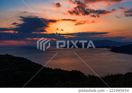 Beautiful sunset over the Kii Straits in Wakayama. Beautifully shining sunset clouds framed by the setting sun Beautiful sunset over the Kii Straits in Wakayama. Beautifully shining sunset clouds framed by the setting sun 122995654