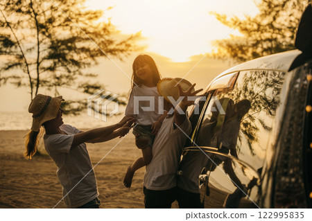 Asian family playing near car window at sunset feeling funny in holidays and relaxation together. Happy weekend travel enjoy summer at beach. summer vacation travel driving road trip concept Asian family playing near car window at sunset feeling funny in holidays and relaxation together. Happy weekend travel enjoy summer at beach. summer vacation travel driving road trip concept 122995835