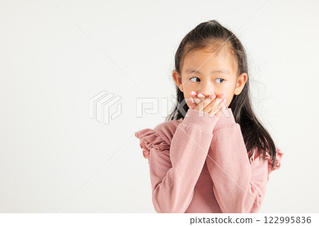 Asian portrait young kid girl standing surprised excited shocked covering mouth with hands for mistake on white background, kindergarten child secret concept with copy space for text 122995836