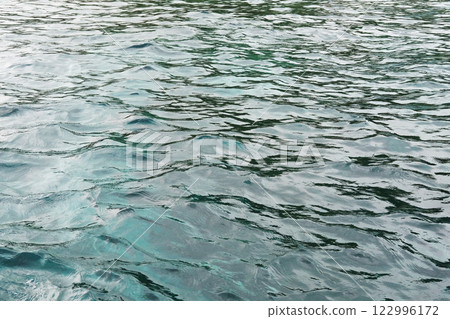 Emerald green waters and turquoise surface of blue sea wave and water background of shore. Travel destination summer of ocean 122996172