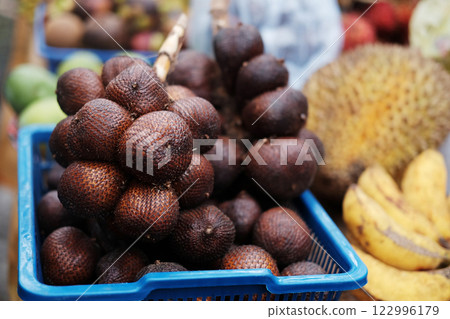 Fresh salak fruits branch in blue plastic basket at the market Fresh salak fruits branch in blue plastic basket at the market 122996179