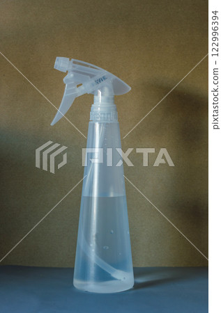 Clear plastic spray bottle filled with water isolated against neutral background. High quality photo Clear plastic spray bottle filled with water isolated against neutral background. High quality photo 122996394