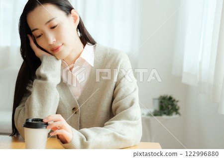 Businesswoman sitting at a table and thinking 122996880
