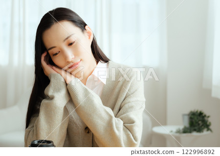 Businesswoman sitting at a table and thinking 122996892