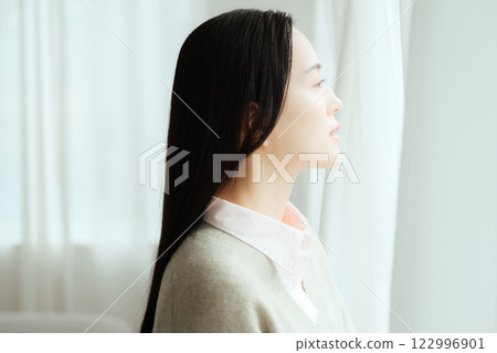 Businesswoman looking out of the office window 122996901