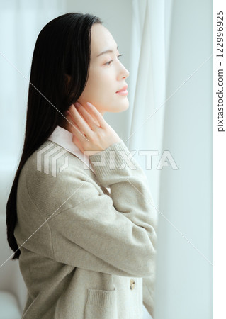 Businesswoman looking out of the office window Businesswoman looking out of the office window 122996925