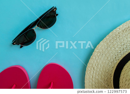 Summer vacation. Flip flops, sunglasses and a hat on a blue background. 122997573