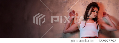 A Stylish Young Woman Posing Elegantly Against a Beautifully Textured Wall Background A Stylish Young Woman Posing Elegantly Against a Beautifully Textured Wall Background 122997792