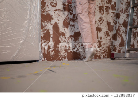 A Woman Using Her Creativity to Paint Walls in a Home Renovation Project Effectively 122998037
