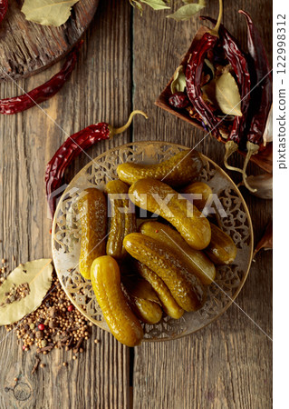 Pickled cucumbers with ingredients on an old wooden table. Pickled cucumbers with ingredients on an old wooden table. 122998312