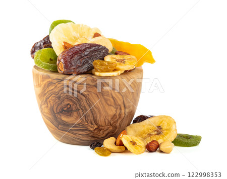 Dried tropical fruits, nuts, and raisins isolated on white. 122998353