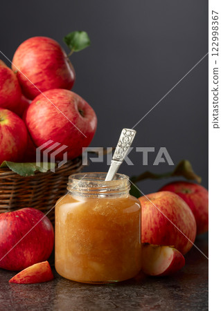 Apple jam and fresh apples on a black stone table. Apple jam and fresh apples on a black stone table. 122998367