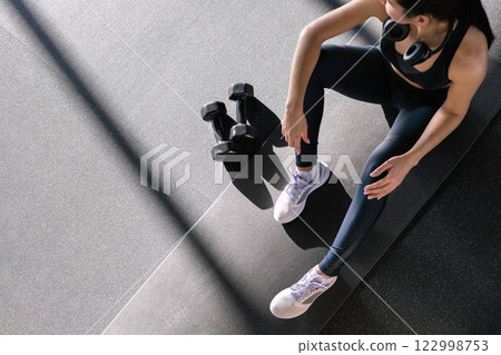 Fitness asian woman legs sitting on sport mat training with dumbbells closeup top view. 122998753