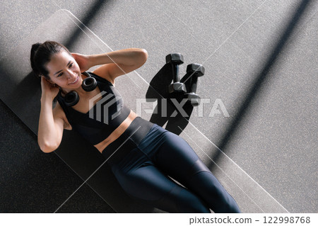 Beautiful athletic Asian woman trains in gymnastics studio, enjoys flexibility, healthy lifestyle Beautiful athletic Asian woman trains in gymnastics studio, enjoys flexibility, healthy lifestyle 122998768