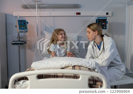 A Compassionate Doctor and a Happy Patient Together in a Hospital Room Environment 122998904