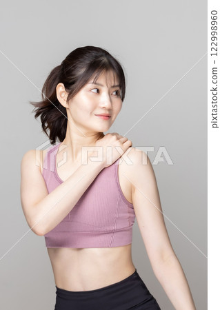 Beautiful woman in sportswear stretching 122998960