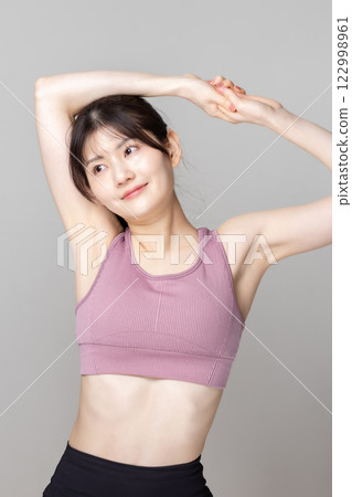 Beautiful woman in sportswear stretching Beautiful woman in sportswear stretching 122998961