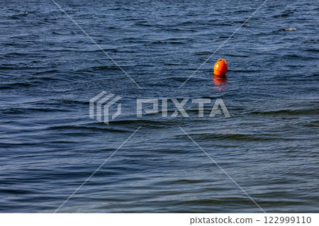 A vibrant Floating Buoy is situated quietly on calm water, creating a picturesque scene 122999110