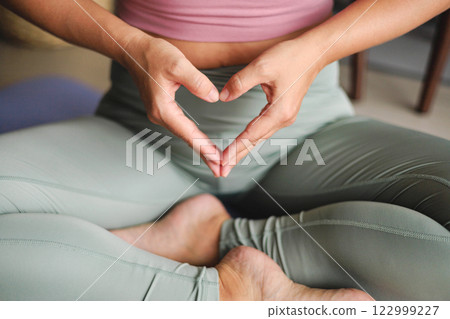 Yoga woman in lotus position with hands heart shape closeup. Yogi spiritual female asana with love 122999227