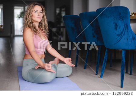 Yoga woman meditation in lotus pose with signing bowl sitting on mat at home Yoga woman meditation in lotus pose with signing bowl sitting on mat at home 122999228