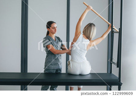 Spine exercises. Woman is in health center getting help by doctor 122999609