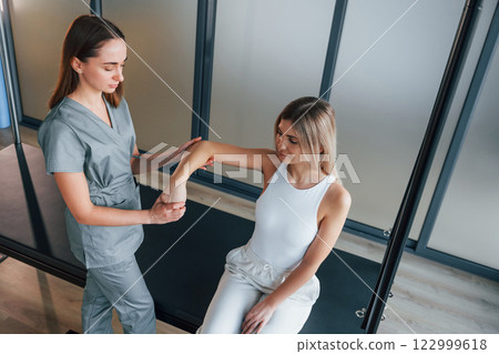Moving the hand. Woman is in health center getting help by doctor 122999618