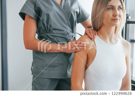 Doing massage. Woman is in health center getting help by doctor Doing massage. Woman is in health center getting help by doctor 122999626
