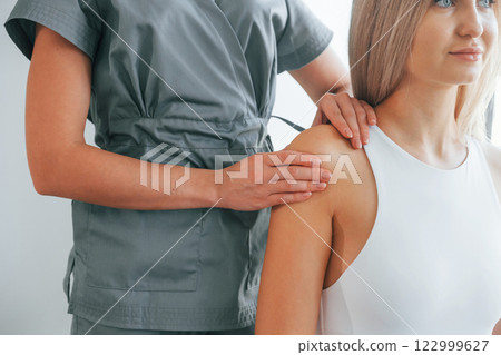 Doing massage. Woman is in health center getting help by doctor Doing massage. Woman is in health center getting help by doctor 122999627
