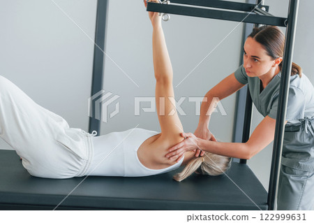 Using special equipment. Woman is in health center getting help by doctor Using special equipment. Woman is in health center getting help by doctor 122999631
