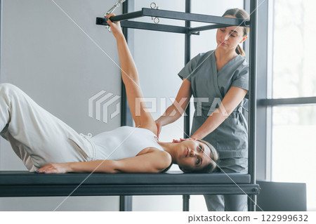 Using special equipment. Woman is in health center getting help by doctor Using special equipment. Woman is in health center getting help by doctor 122999632