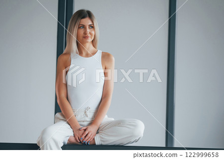 Woman in sportive clothes is standing in the studio 122999658