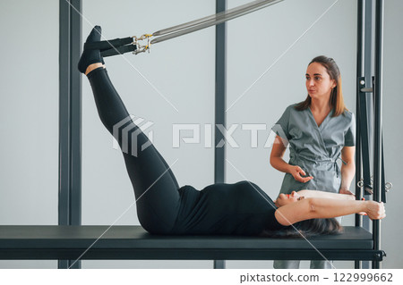 Active exercises. Woman is in health center getting help by doctor 122999662