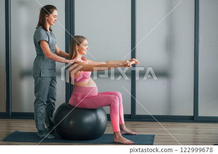 Pregnant woman is in health center getting help by doctor Pregnant woman is in health center getting help by doctor 122999678