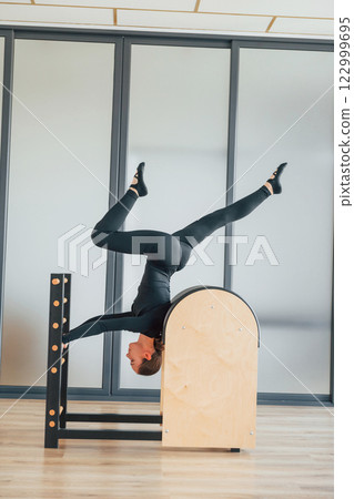 Doing tricks. Woman in sportive clothes is in the studio 122999695