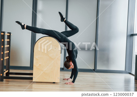 Using special equipment. Woman in sportive clothes is in the studio Using special equipment. Woman in sportive clothes is in the studio 123000037
