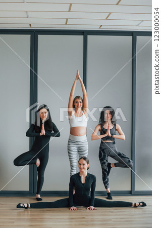 Yoga session. Women in sportive clothes standing in the fitness center Yoga session. Women in sportive clothes standing in the fitness center 123000054