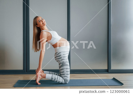 Pregnant woman in sportive clothes is in the studio 123000061