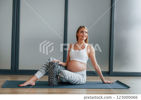 Yoga for pregnant. Woman in sportive clothes is in the studio Yoga for pregnant. Woman in sportive clothes is in the studio 123000066