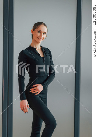 Standing and posing. Woman in sportive clothes is in the studio 123000083