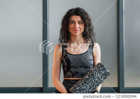 Standing and posing. Woman in sportive clothes is in the studio Standing and posing. Woman in sportive clothes is in the studio 123000094