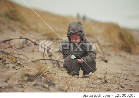 Adorable child playing near the sea in winter in Denmark 123000203