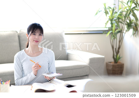 A young woman studying alone in the living room A young woman studying alone in the living room 123001509