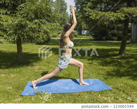 Side view of young woman doing yoga in the park Side view of young woman doing yoga in the park 123001594