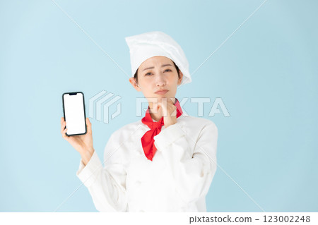 Female chef cook coat smartphone worries 123002248