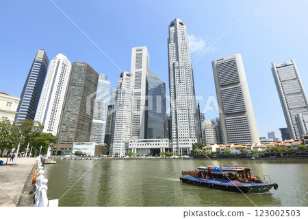 Panoramic view of the Sightseeing Bumboats cruising on the Singapore River and the Financial District skyscrapers along the shore. 123002503
