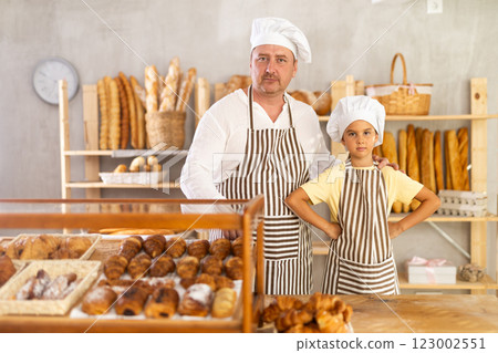 Dad and little daughter work sell in family bakery shop 123002551