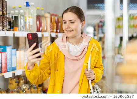 Young woman choosing groceries while makes video call 123002557